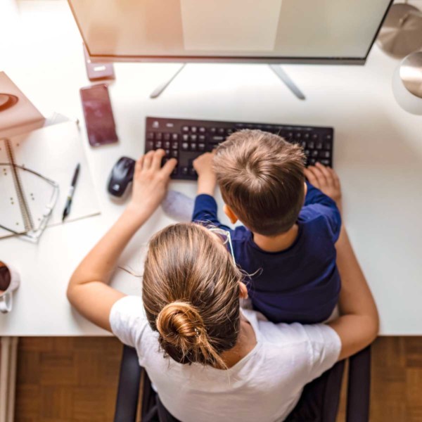 Image of a child and their parent using a computer.