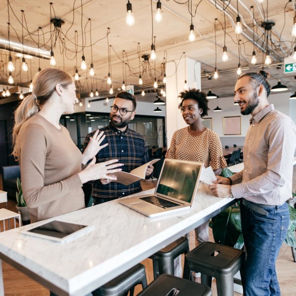 four people working together on a project in a very modern office space