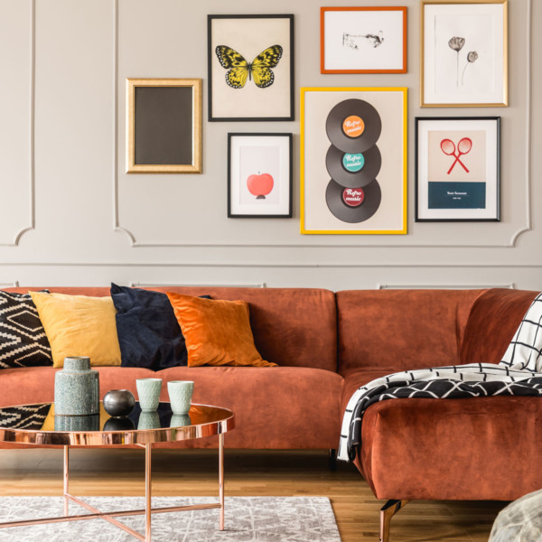 living room with red couch and vertical space used well with wall decor and paintings