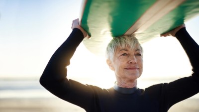 Image of someone holding a surfboard over their head.