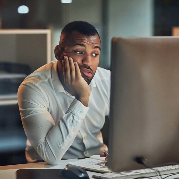 Man frustrated sitting at computer doing work