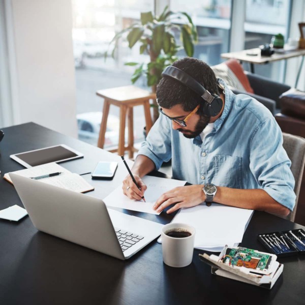 man working at his desk at home with coffee