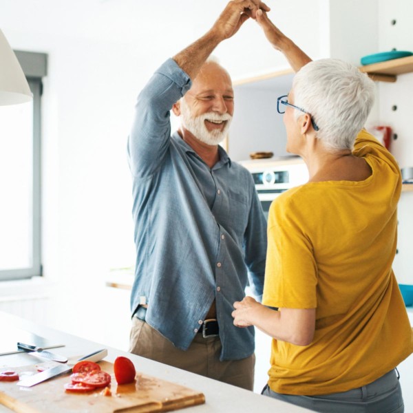 Older couple dancing in the kitchen while cooking