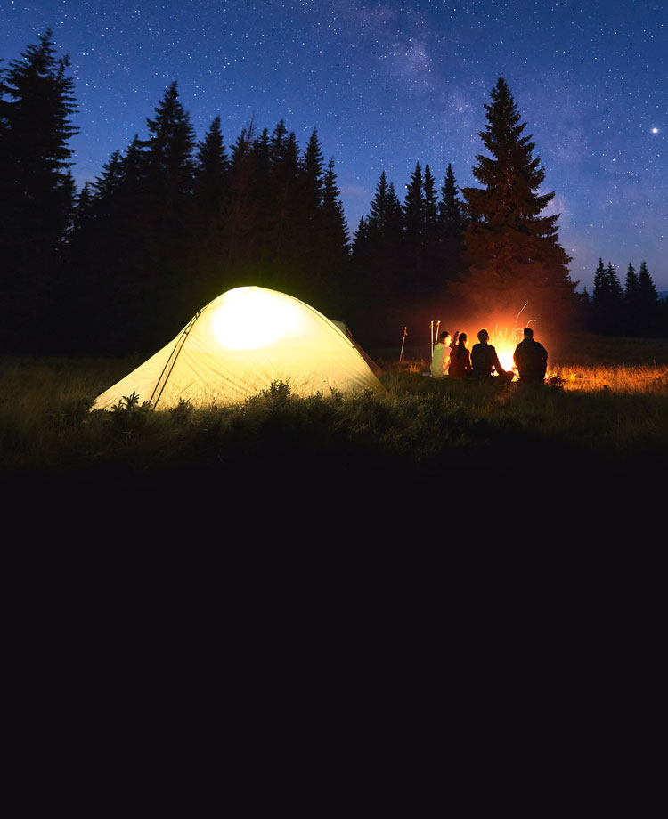Image of a group of people camping outside at night.