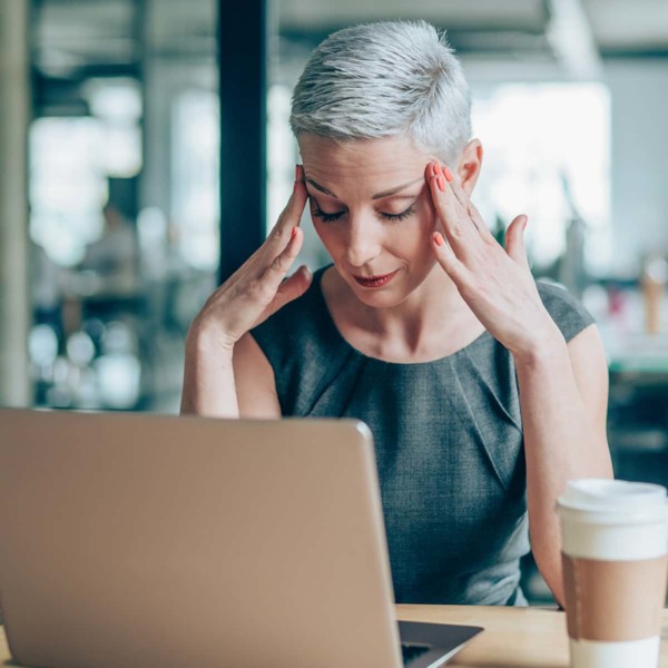Image of someone rubbing the sides of their head while working.