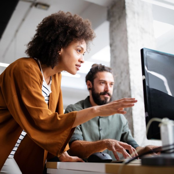 two people working collaboratively on a project at a desk