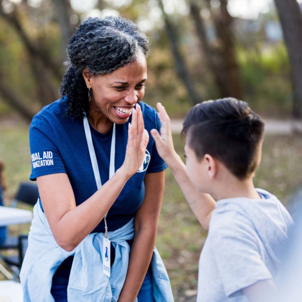 women high fiving a child while at a volunteer event