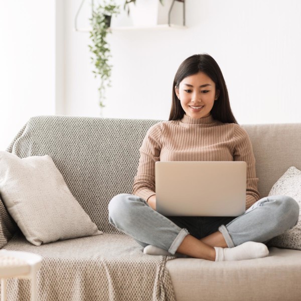 women researching charities on her laptop on her couch