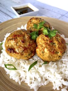Three turkey meatballs sitting on a bed of rice