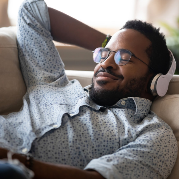 Image of someone on the couch with headphones on.