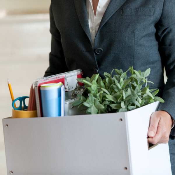 woman packing up office items as she lost her job but managed debt with an emergency fund