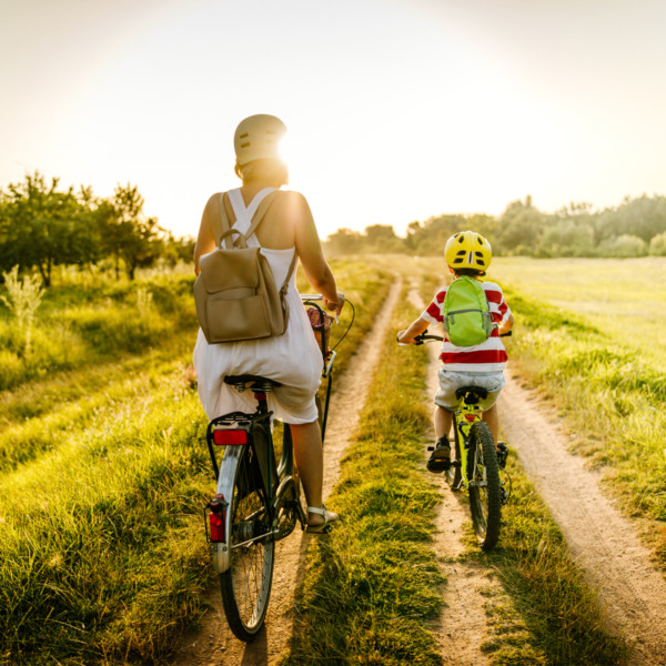 Mother and son riding bikes through grass