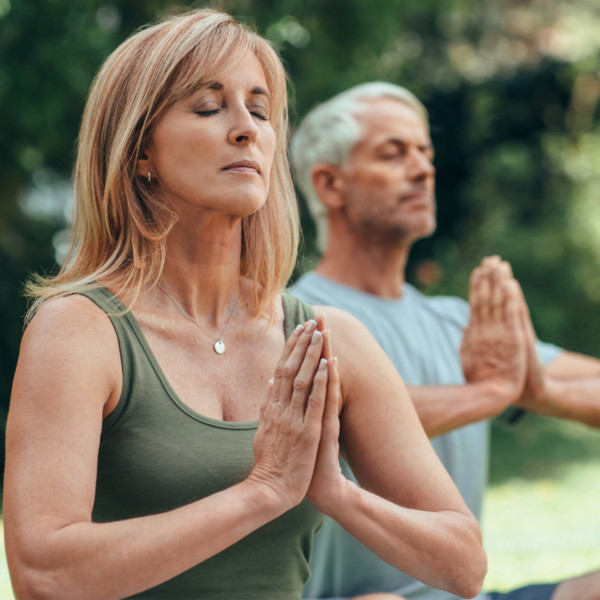 Older couple doing yoga outside