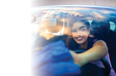 Woman cleaning the inside of her car windshield