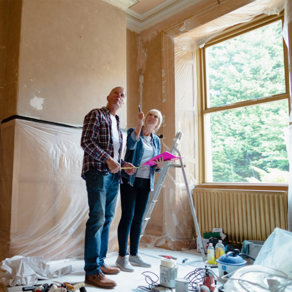 Image of an elderly couple working on their house.
