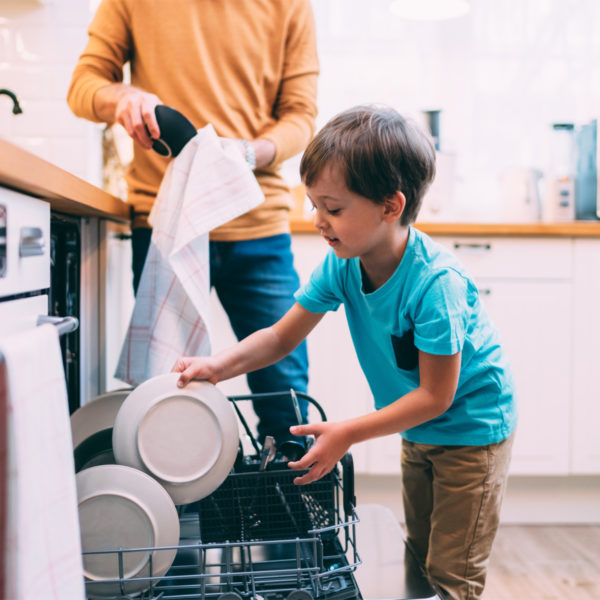 Image of a child with their parent, washing dishes.