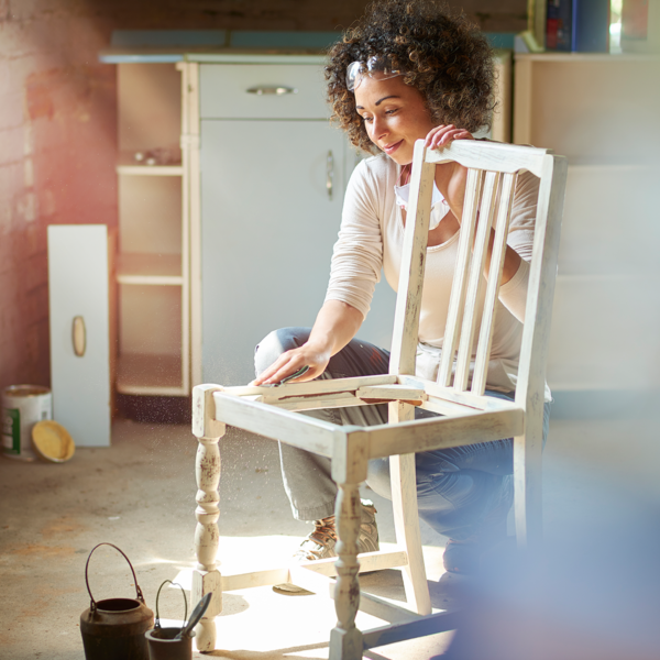 Woman refinishing chair