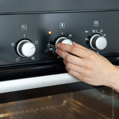 Turning the stove to a higher temperature to cook chicken and rice