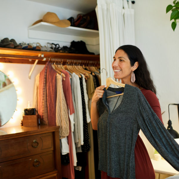 Woman holding up potential shirt for work from home outfit