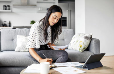 Woman working from home on the couch in her fashionable work wardrobe