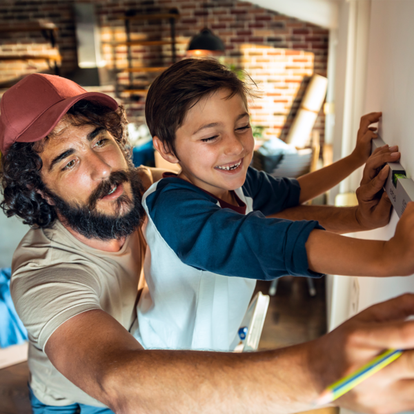 Man helping son measure wall